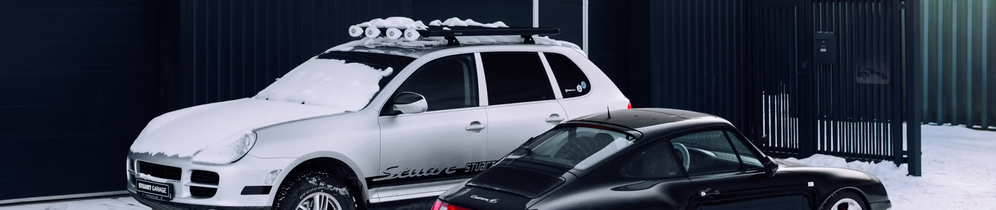 Gray car with snow-covered roof and hood parked.